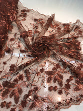 Floral thread embroidered with sequins embroidered on top of it on meah fabric sold by the yard