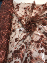 Floral thread embroidered with sequins embroidered on top of it on meah fabric sold by the yard