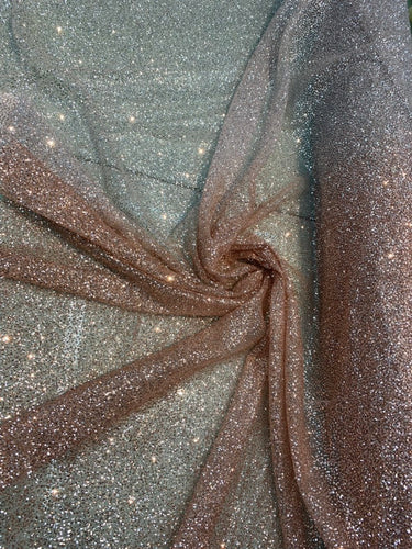 Glitter Metallic tule fabric useable for apparel, party Decore etc...& much more.  58â wide beautiful ombrÃ© pinkish gold color.